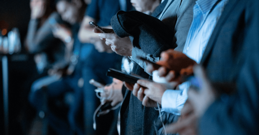 Foto de pessoas lado a lado utilizando smartphones